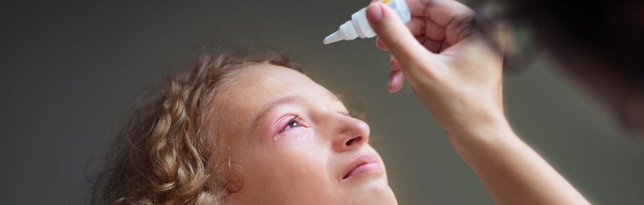Child with injured eye having drops
