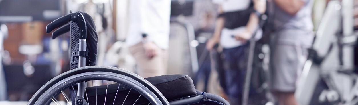Close up of wheelchair with person using crutches